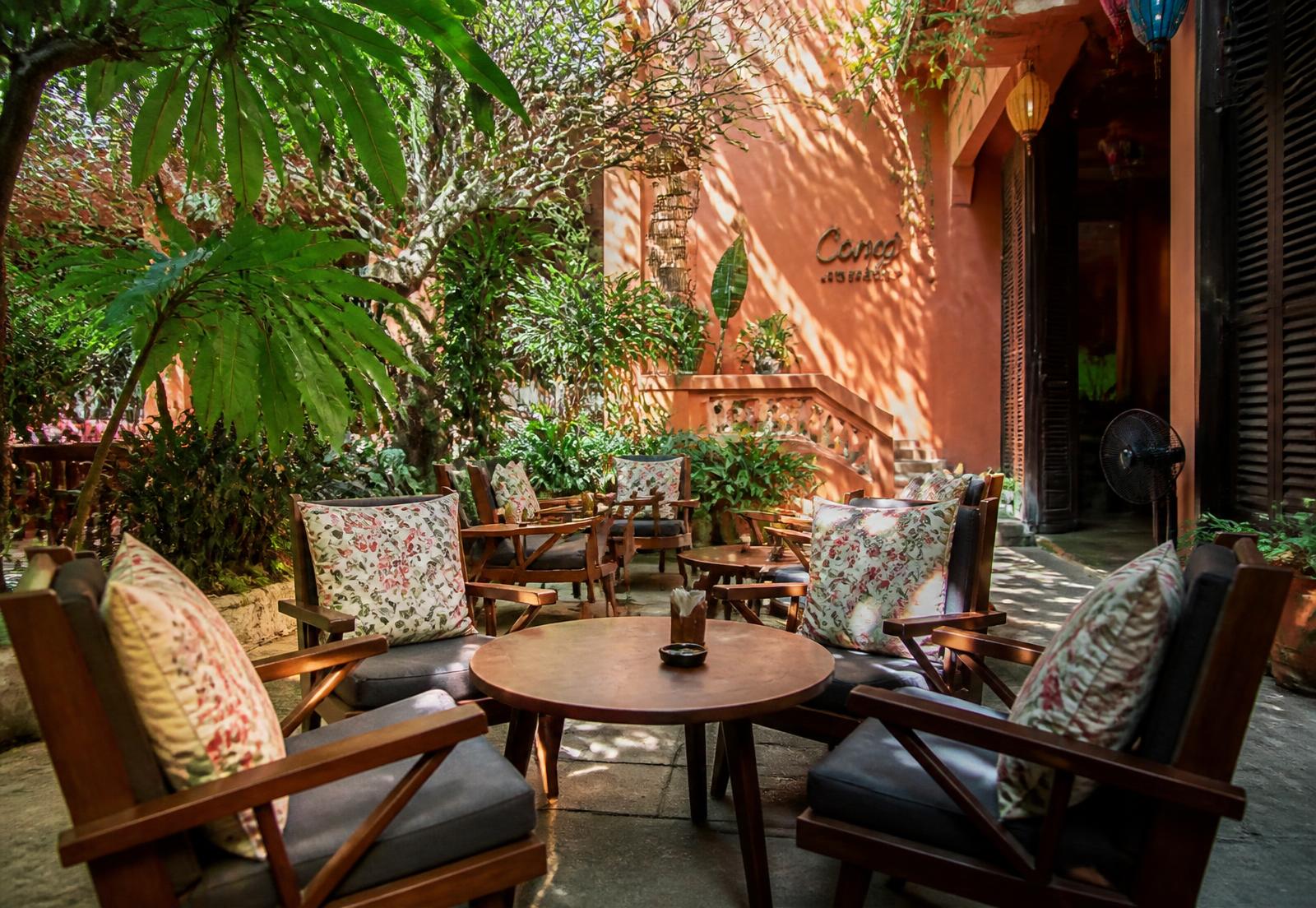 Shaded outdoor garden seating surrounded by tropical plants
